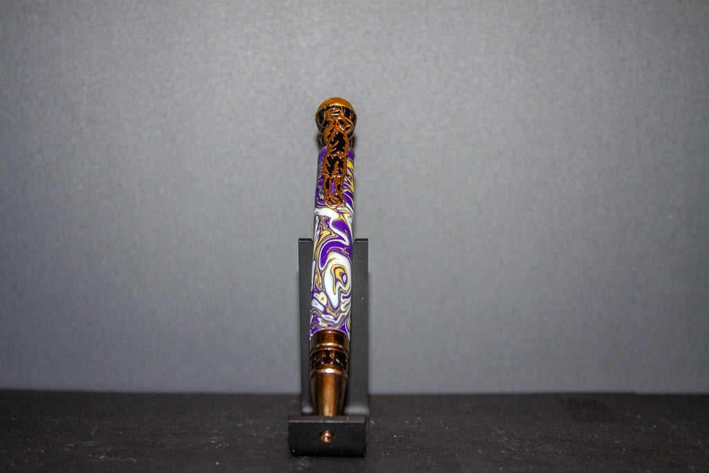 Decorative pen with purple and gold design on a gray background