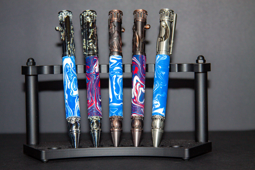 Set of five artistic pens on a stand with a gray background